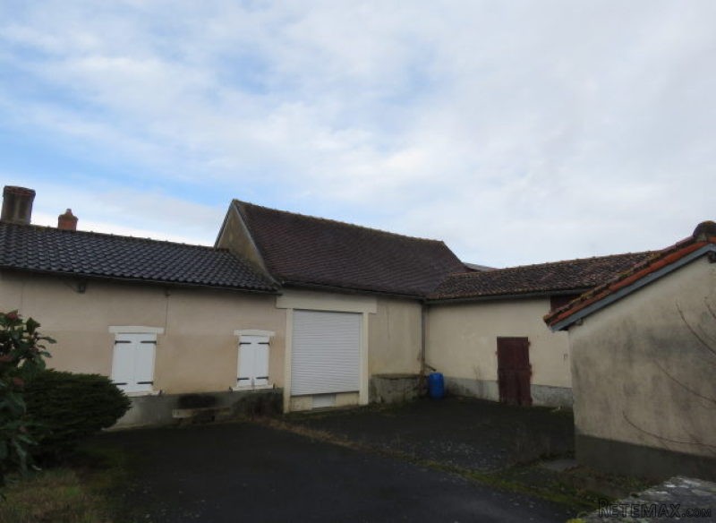 House with barns and small wood.